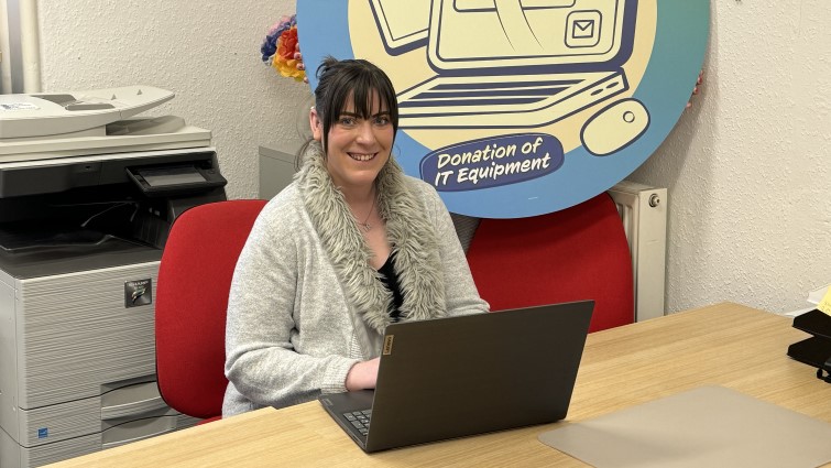 This image shows a representative of Charity Skills Exchange with a laptop donated thanks to the Community Wish List