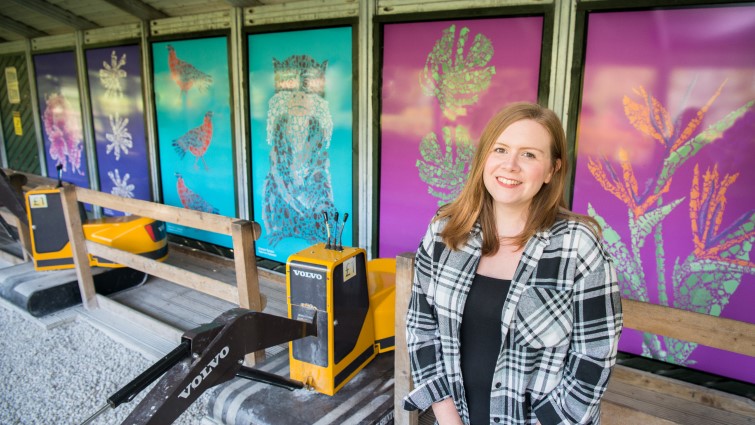 SLLC art tutor Kayleigh is pictured standing in front of the new murals.