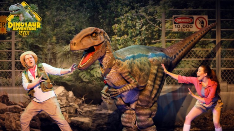 Two actors face up to a Tyrannosaurus Rex on stage in the Dino Live show.