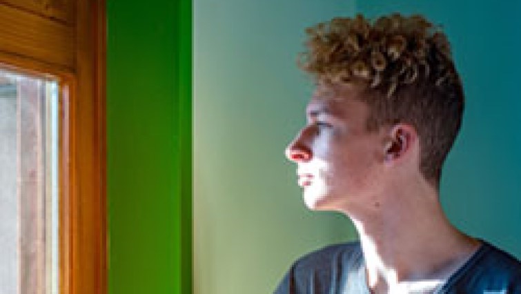 young person looking out a window