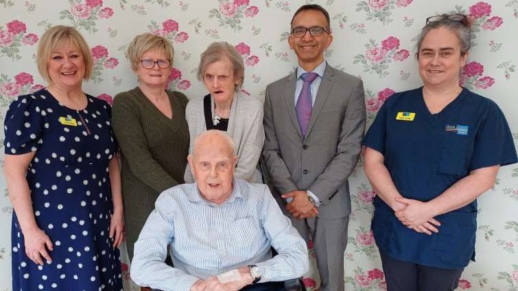 This image shows staff and residents of McKillop Gardens care home with Professor Soumen Sengupta