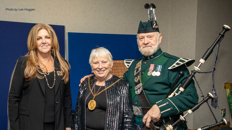 This image shows Provost Margaret Cooper and Lady Susan Haughey with a piper at the Burns supper event for Kilbryde hospice