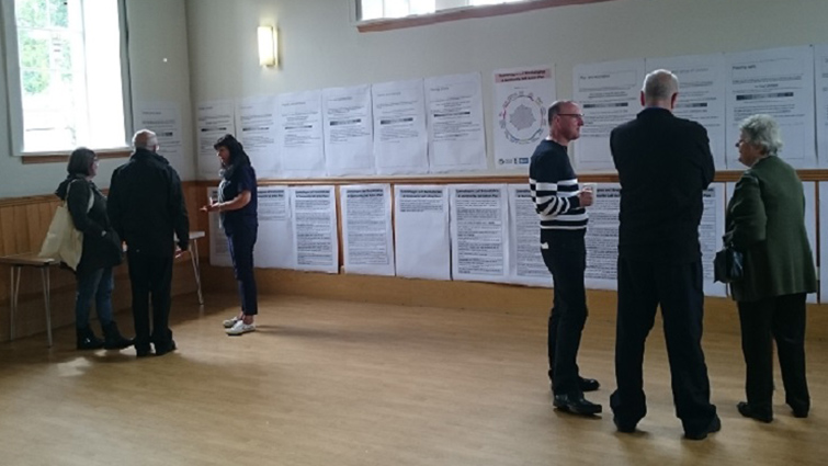 Residents of Lesmahagow examine the wall-mounted plans for the community