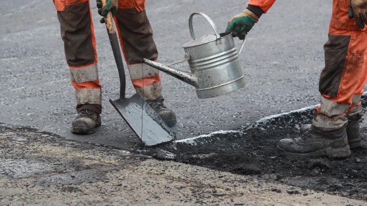 resurfacing road - closeup using liquid tar