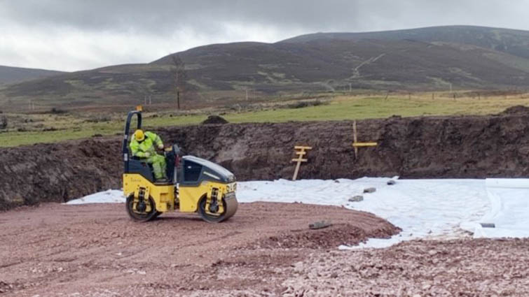 This is a picture of a worker on a yellow road roller preparing the ground in the new car park extension at Tinto