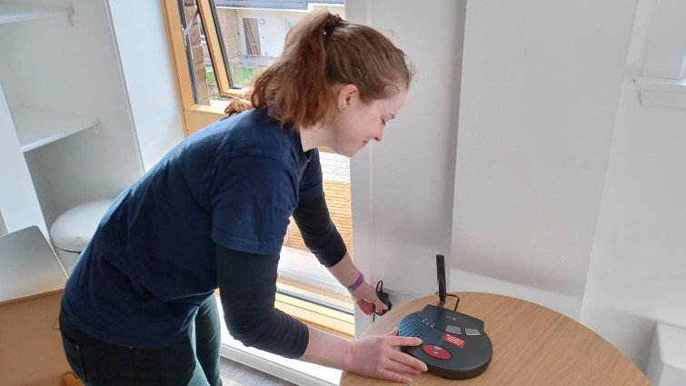 TEC assistant Caty Cameron installs a digital community alarm.