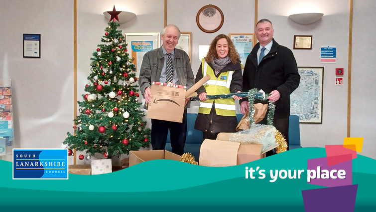 Councillor Robert Brown, the  Chair of Community and Enterprise Resources with grounds services team next to Christmas Tree and boxes of festive waste material 