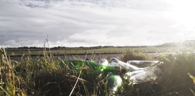 This photo shows a pile of bottles discarded by the road side on Airdrie Road, Carluke.
