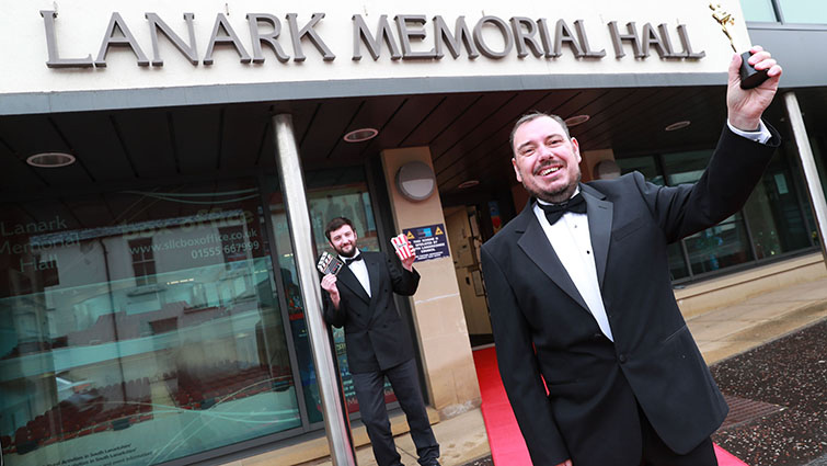 Two South Lanarkshire Leisure and Culture employees outside Lanark Memorial Hall to publicise the movies which will be screened at the venue