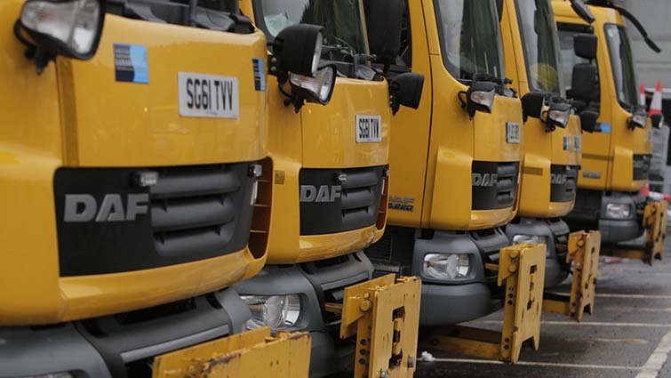 Four of the council's fleet of gritters are shown lined up and ready to go. 