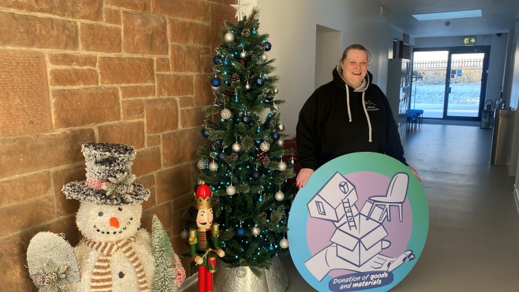 This image shows a member of the Old Schoolhouse committee with a Christmas tree following a successful bid to the council's community wish list