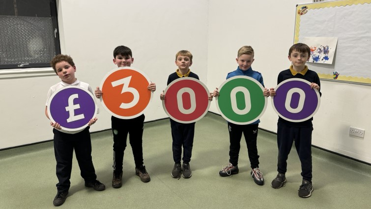 This image shows some of the young people who attend Circuit Youth Club holding up figures to represent the £3000 they were awarded following a Participatory Budgeting exercise