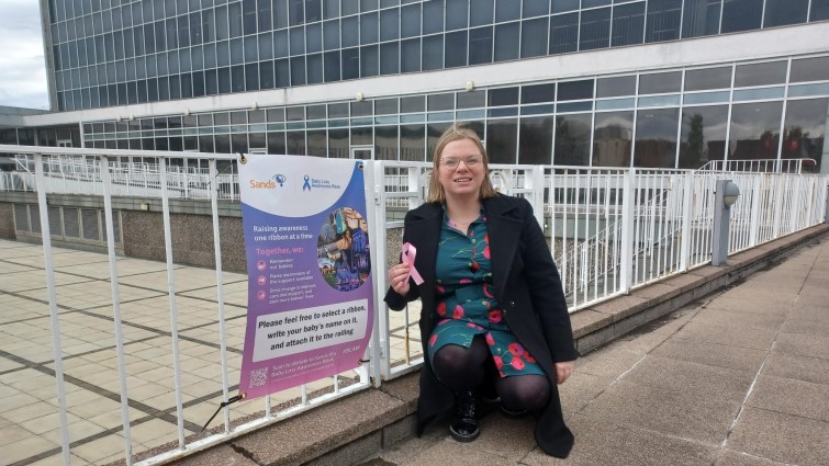This image shows Councillor Lynsey Hamilton outside SLC HQ where ribbons can be placed in memory of babies who lost their lives too soon