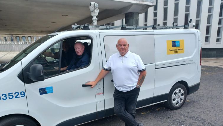 This image shows Councillor Davie McLachlan leaning on one of the council's CCTV vans with a member of staff looking out the window