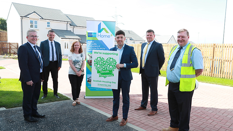 At the centre of the picture councillor Josh Wilson is holding a Scottish Housing Day 2021 poster. There are five other people in the photo representing council Housing services and delivery partners in new housing projects