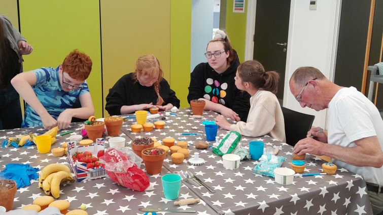Adults and children working on a table top project 