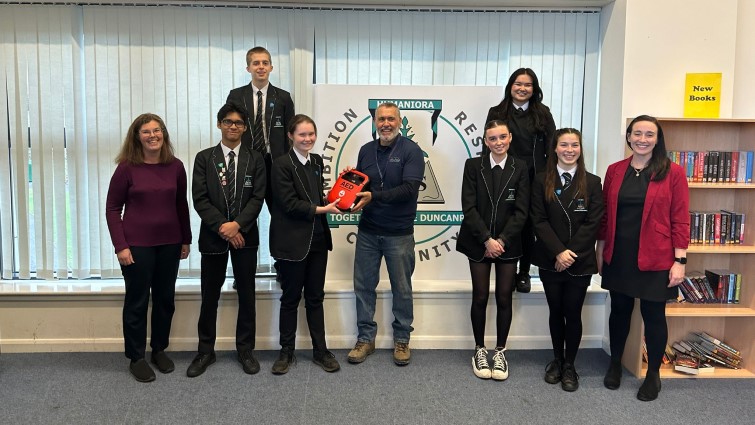 Highlander International’s CEO, Brian Bingham, present's a defibrillator funded by his company to pupils and staff at Duncanrig Secondary School, East Kilbride. 