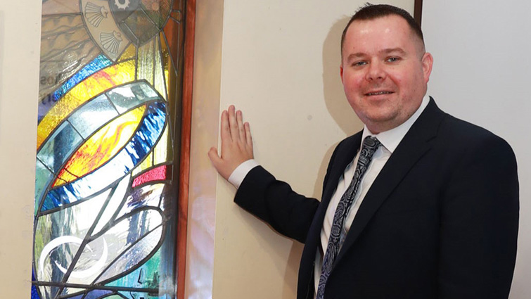This photo shows Councillor Fagan standing next to a new stained glass window, commissioned earlier this year to mark EK75 and now installed in EK Arts Centre. 