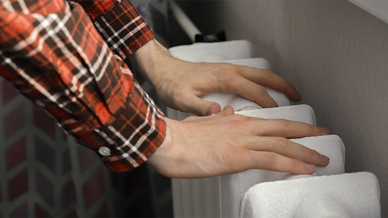 This images shows hands on a radiator 