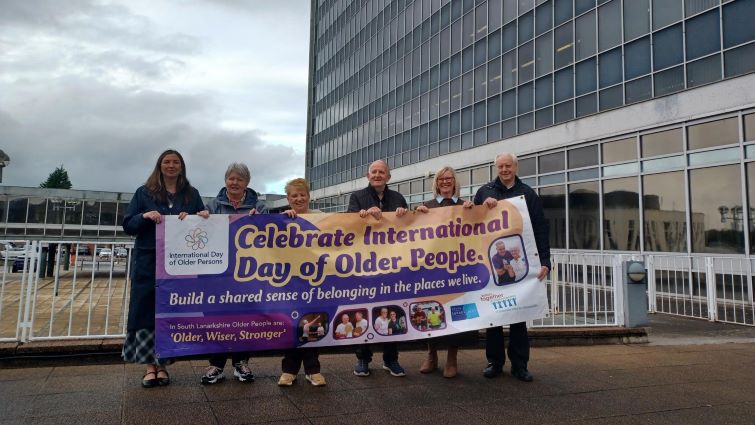This image shows council staff, members of Seniors Together and Councillor Eileen Logan outside council HQ with a banner that says Celebrate International Day of Older People