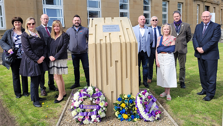 This image shows trade union officials and the council's chief exec at the memorial for workers on International Workers Memorial Day 
