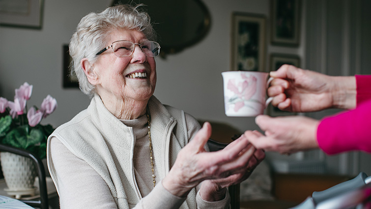 This image shows Jessie Turner, who has praised the care she has received, being given a cup of tea