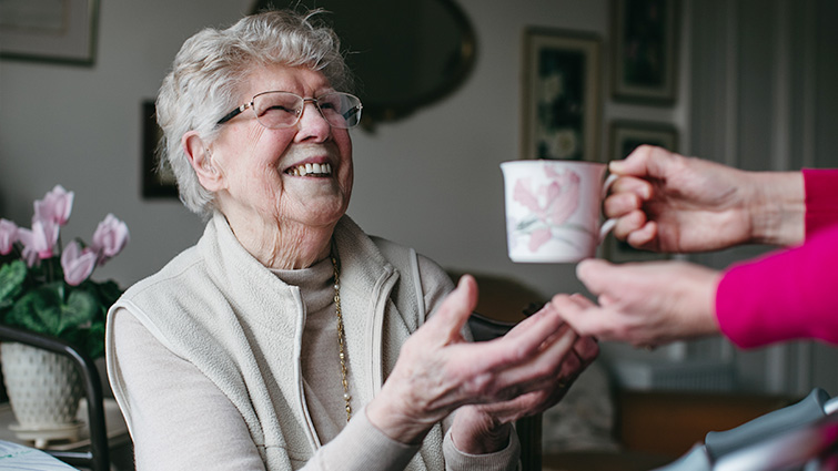 This image shows Jessie Turner, who has praised the care she has received, being given a cup of tea 