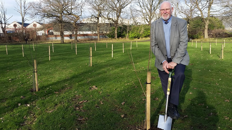 This image shows the Council Leader at Bothwell Road park with trees that have been planted in memory of those in South Lanarkshire who lost their lives to Covid-19 