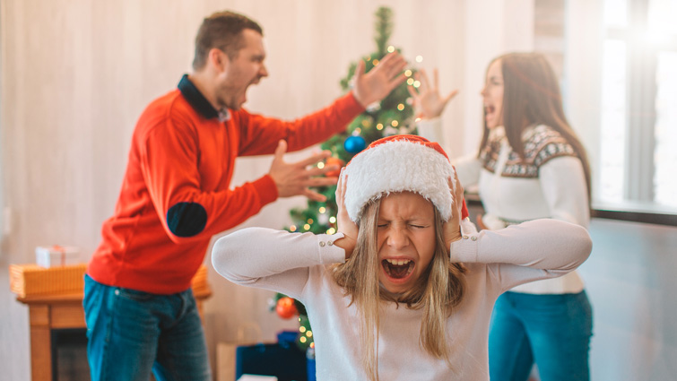 This image shows parents arguing with a child covering their ears with a Christmas theme