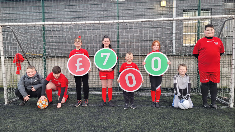 This photo shows young people who attend Fernhill Soccer School holding numbers which represent the amount the group was awarded through Participatory Budgeting funding 