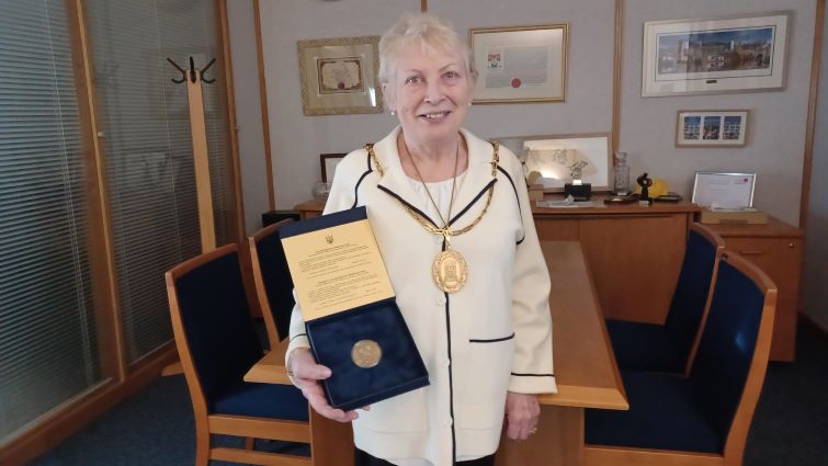 This image shows Provost Margaret Cooper holding a replica of the Hero City medal from Kharkiv Deputy Mayor Oleksander Novak