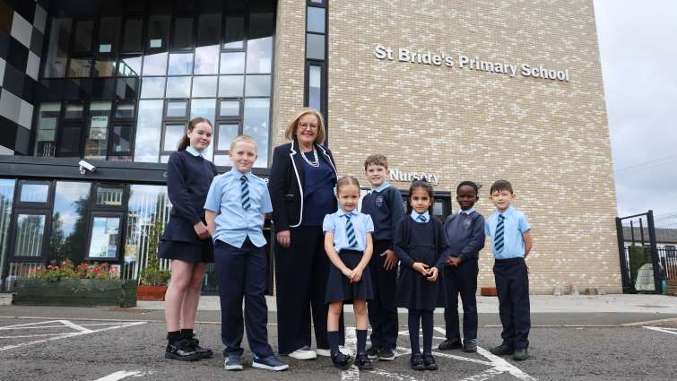 head teacher Louise Torrance and pupils outside entrance to St Bride's Primary School and Nursery