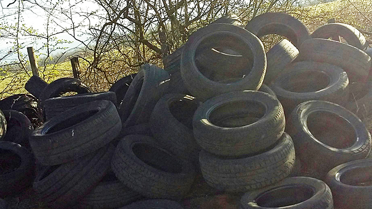this picture shows the masses of tyres piled up and dumped by the roadside in Blantyre.
