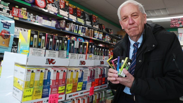 This is a photo of Councillor Robert Brown in a South Lanarkshire shop. He is standing alongside a display of single-use vapes. 