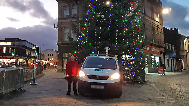 This image shows one of our community wardens in front of the Christmas tree in Hamilton 