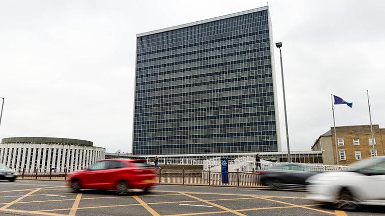 Photo shows South Lanarkshire Council Headquarters with cars passing by in the foreground