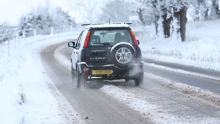 A car makes its way down a South Lanarkshire road following snow 