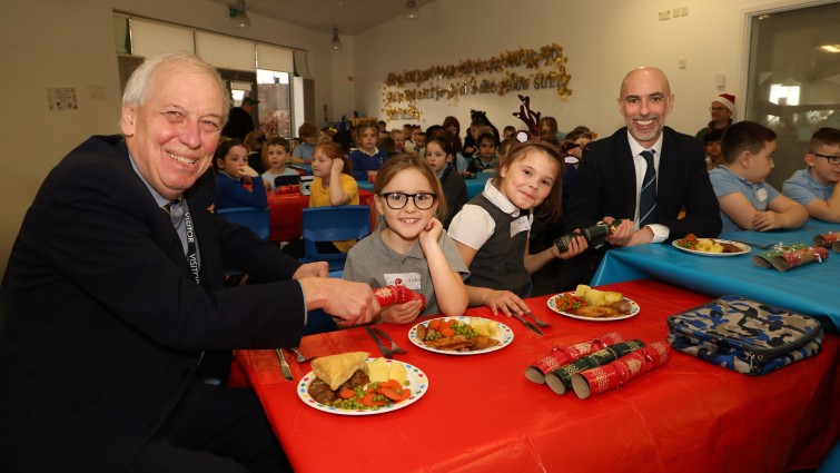This image shows Councillor Robert Brown and Kevin Carr with pupils from Spittal PS at their Christmas lunch