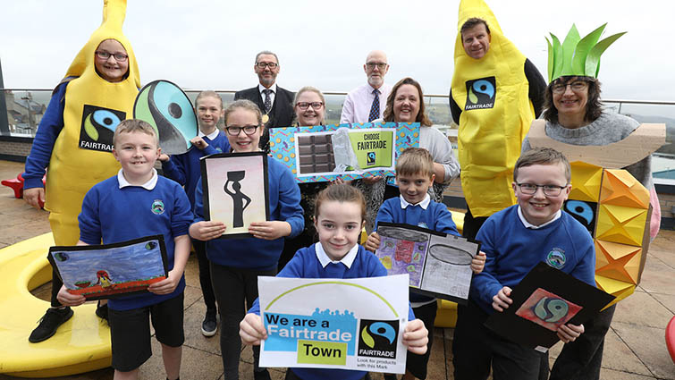 A group of six pupils from Biggar Primary School, with members of the town's Fairtrade Steering Group, Provost Ian McAllan and two men dressed as life sized bananas, show off the town's Fairtrade Directory. 