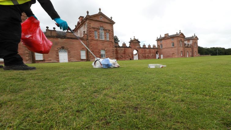 This picture shows a litter picker lifting rubbish from the front lawns at Chatelherault Hunting lodge.