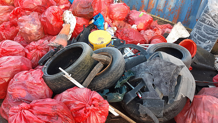 The picture shows a huge collections of bags full of litter and dumped rubbish including a toilet, tyres and canisters of oil and paint.