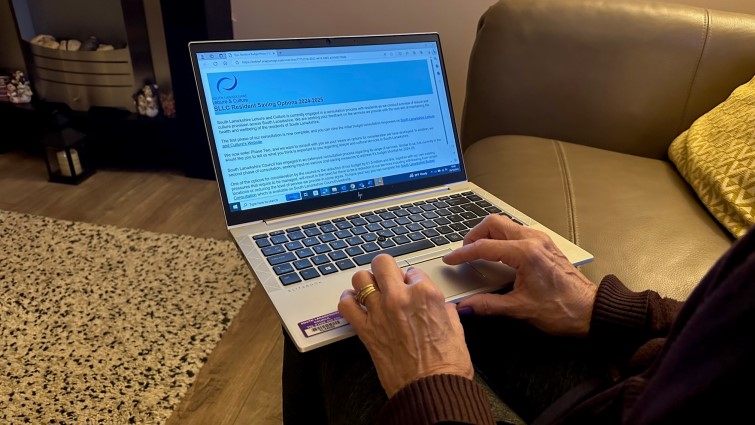 A resident using a laptop to access the SLLC online consultation.