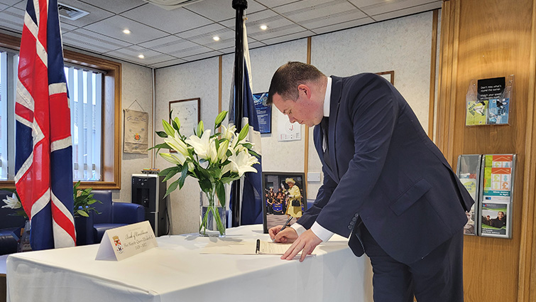 This image shows council leader Joe Fagan signing the book of condolence following the death of HM The Queen