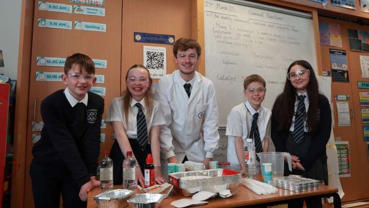 pupils and teacher conducting a science experiment
