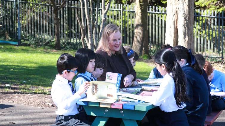 Calderwood Primary School head teacher Jennifer Innes reading outdoors with pupils