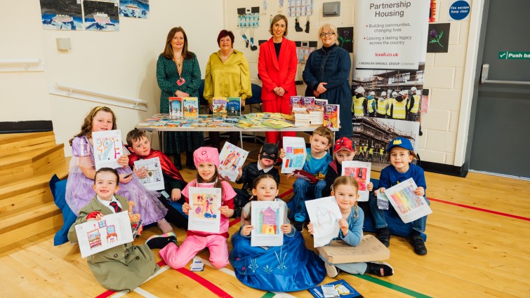 pupils with their drawings of a future home with education staff and Lovell representative