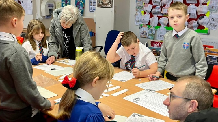 St Louise Primary School classroom with pupils parents and teachers around a desk